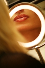 Feminine face in makeup mirror